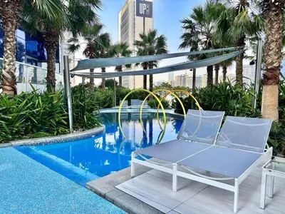 a blue chair sitting next to a swimming pool at FIRST CLASS 2BR Mesmerizing Burj Khalifa View in Dubai