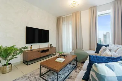 a living room with a flat screen tv on a wall at 2BR Downtown Gem with Burj Khalifa and Fountain Views in Dubai