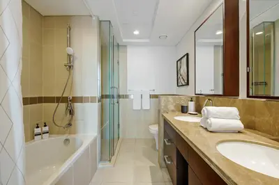 a bathroom with two sinks and a tub and a shower at 2BR Downtown Gem with Burj Khalifa and Fountain Views in Dubai