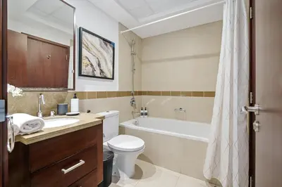 a bathroom with a tub and a toilet and a sink at 2BR Downtown Gem with Burj Khalifa and Fountain Views in Dubai