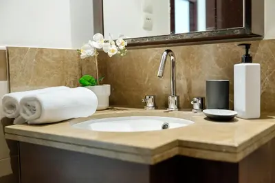 a bathroom counter with a sink and a mirror at 2BR Downtown Gem with Burj Khalifa and Fountain Views in Dubai