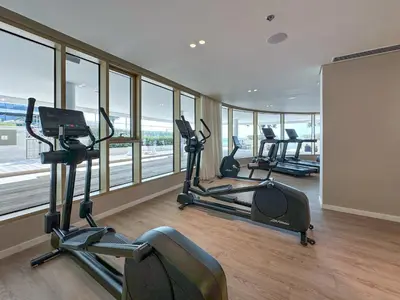a gym with several exercise bikes in a room with windows at Fantastic 2BR apartment Palm, Sea and Sunset Views in Dubai