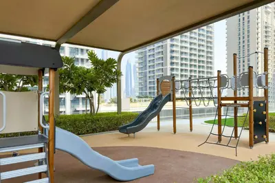 a play area with a slide and a playground at Fantastic 2BR apartment Palm, Sea and Sunset Views in Dubai