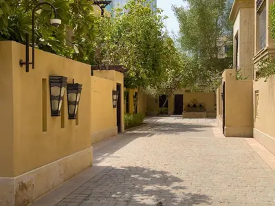 an empty alleyway with a yellow wall and trees at Central & Luxurious 2BR- Burj Khalifa & Dubai Mall in Dubai