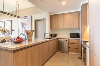 a kitchen with wooden cabinets and a bowl of fruit on the counter at The Smart Concierge - Stella Maris in Dubai