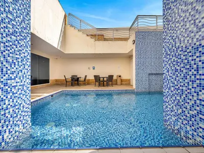 a swimming pool with blue tiles on the side of a house at Elegant 3BR Lux Stay in the Heart of Dubai Marina in Dubai
