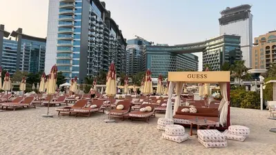 a bunch of chairs and umbrellas on a beach at Beachfront Bliss, Seven Palm Studio Apartment in Dubai