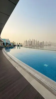 a swimming pool with a city skyline in the background at Beachfront Bliss, Seven Palm Studio Apartment in Dubai