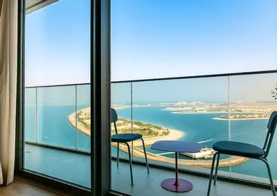 a balcony with two chairs and a view of the ocean at Serene Ocean Views, 2BR Emaar Beachfront in Dubai