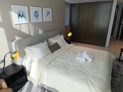 a bedroom with a large white bed with towels on it at Luxury Studio | Near Dubai Mall | Lake View in Dubai