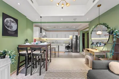 a kitchen and living room with a table and chairs at Modern Apt just Steps to Metro & Lake with Pool andParking in Dubai