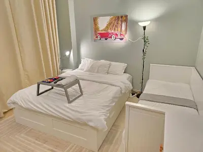 a small bedroom with two beds with a table on it at Modern Studio Near Dubai World Trade Centre in Dubai