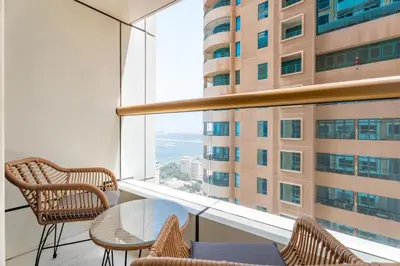 a room with a table and chairs and a large window at Gala Guests - Elite Sea View Suites Dubai Marina in Dubai