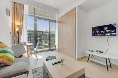a living room with a couch and a table at Waves - Stylish and Comfy Couples Retreat Apt with Balcony in Dubai