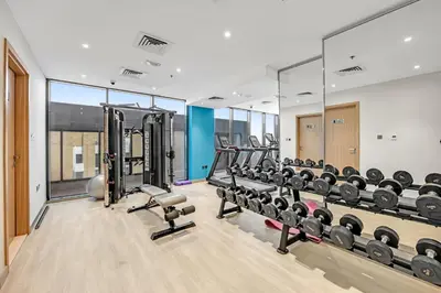 a gym with rows of treadmills and machines at Waves - Stylish and Comfy Couples Retreat Apt with Balcony in Dubai