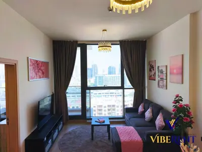 a living room with a couch and a large window at 1BHK Pool Sauna 15 Min to Marina in Dubai