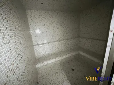 a bathroom with a shower with a tiled floor at 1BHK Pool Sauna 15 Min to Marina in Dubai
