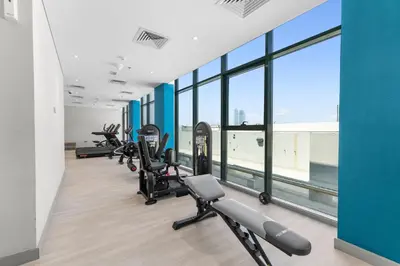 a row of treadmills and exercise bikes in a gym at Urban Chic Apartments in Dubai