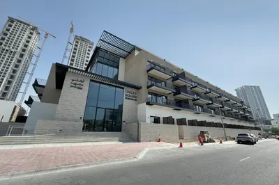 a large building on the side of a street at Modern 1-BR Apartment with Cozy Vibes Pool Gym in Dubai