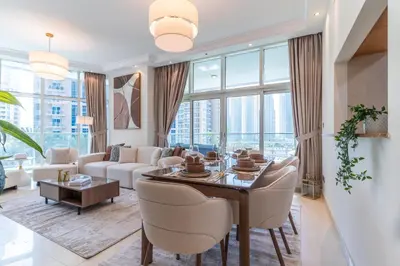 a living room with a table and a couch at The Smart Concierge - Marinascape Avant in Dubai