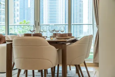 a dining room table with chairs and wine glasses at The Smart Concierge - Marinascape Avant in Dubai