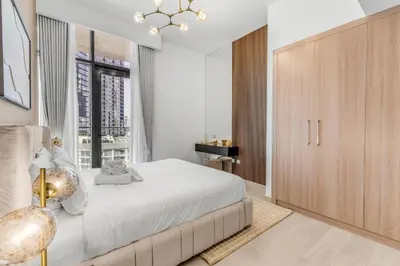a bedroom with a large bed and a large window at Stylish Apartment in Meydan in Dubai