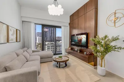 a living room with a couch and a tv at Stylish Apartment in Meydan in Dubai