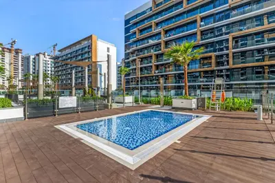 a swimming pool in front of a tall building at Stylish Apartment in Meydan in Dubai
