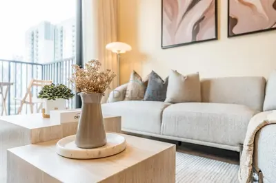 a living room with a couch and a vase on a table at Next to Dubai Hills Park 1BR, Moments from Dubai Hills Mall, Executive Residences 2, Dubai Hills Estate by Deluxe Holiday Homes in Dubai