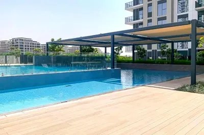 a swimming pool with a pavilion next to a building at Next to Dubai Hills Park 1BR, Moments from Dubai Hills Mall, Executive Residences 2, Dubai Hills Estate by Deluxe Holiday Homes in Dubai