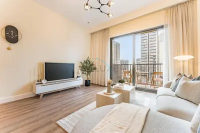 a living room with a tv and a large window at Next to Dubai Hills Park 1BR, Moments from Dubai Hills Mall, Executive Residences 2, Dubai Hills Estate by Deluxe Holiday Homes in Dubai