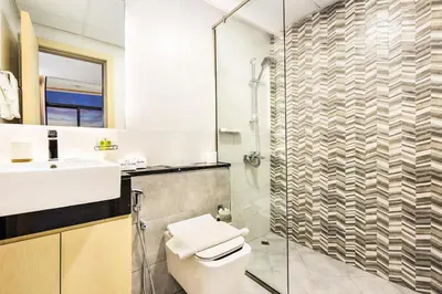 a bathroom with a toilet and a sink and a shower at Spacious 3BR Family Stay with Balcony Views of Burj and City Lights in Dubai