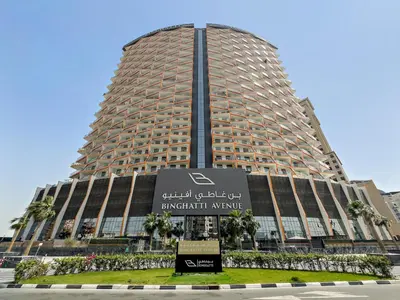 a large building with a sign in front of it at Spacious 3BR Family Stay with Balcony Views of Burj and City Lights in Dubai