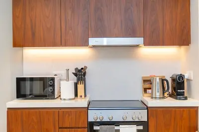 a kitchen with a stove and a microwave at Günstige Unterkunft mit Hafenblick in Port de La Mer in Dubai