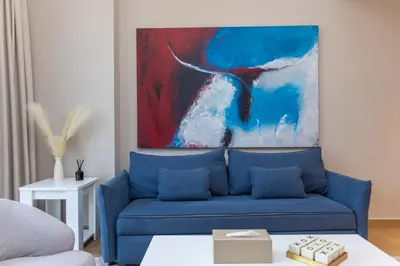 a blue couch in a living room with a painting at Günstige Unterkunft mit Hafenblick in Port de La Mer in Dubai