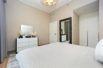 a bedroom with a large white bed and a chandelier at Günstige Unterkunft mit Hafenblick in Port de La Mer in Dubai