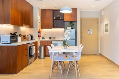 a kitchen with a white table and white chairs at Günstige Unterkunft mit Hafenblick in Port de La Mer in Dubai