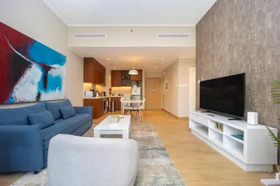 a living room with a blue couch and a tv at Günstige Unterkunft mit Hafenblick in Port de La Mer in Dubai