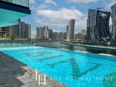 a swimming pool with a city skyline in the background at LUX The Modern Binghatti Canal Suite 3 in Dubai