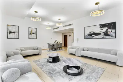 a living room with couches and a table at Chic 2-bed Oasis with Marina Views Walk to Beach! in Dubai