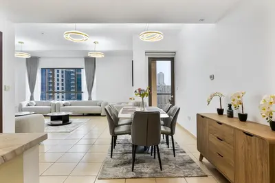 a living room with a table and chairs and a couch at Chic 2-bed Oasis with Marina Views Walk to Beach! in Dubai