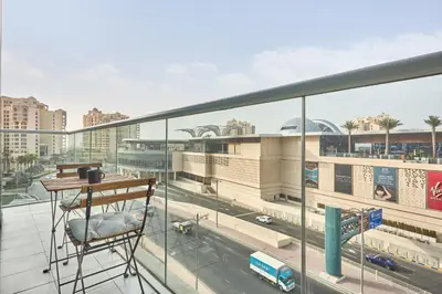 a chair on a balcony with a view of a city at Beachfront Bliss Seven Palm in Dubai