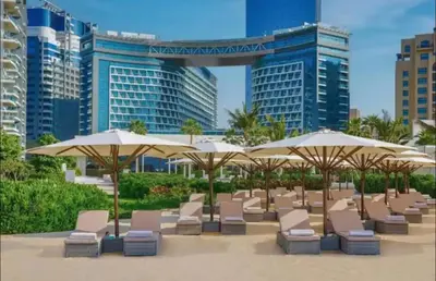 a row of chairs and umbrellas in front of buildings at Beachfront Bliss Seven Palm in Dubai