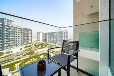 a chair on a balcony with a view of a city at PVH - Azizi Riviera - Lovely Studio near Downtown in Dubai