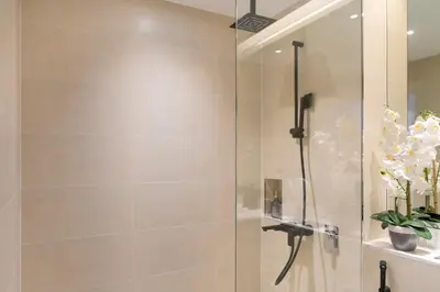a shower with a glass door in a bathroom at Premium Apartment mit Strandzugang in Dubai in Dubai