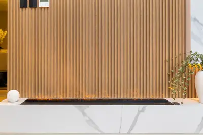 a room with a wooden wall and a table with a vase at Premium Apartment mit Strandzugang in Dubai in Dubai