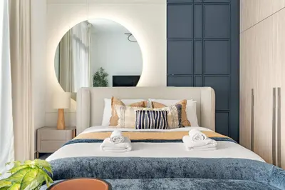 a bedroom with a large bed with towels on it at Silkhaus Chic Studio in Sobha Hartland at Kensington in Dubai