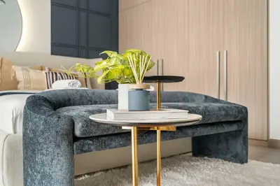 a living room with a blue couch and a table at Silkhaus Chic Studio in Sobha Hartland at Kensington in Dubai