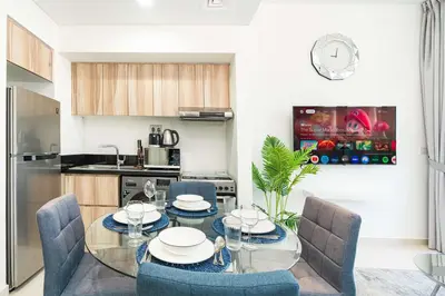 a dining room with a glass table and chairs at PVH - Golf Vita - 1BR with Golf Course View in Dubai