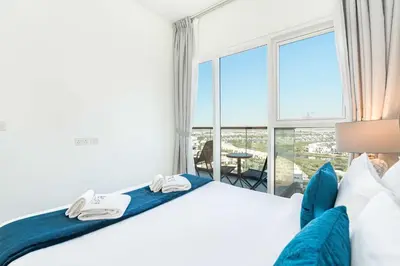 a bedroom with a bed and a large window at PVH - Golf Vita - 1BR with Golf Course View in Dubai